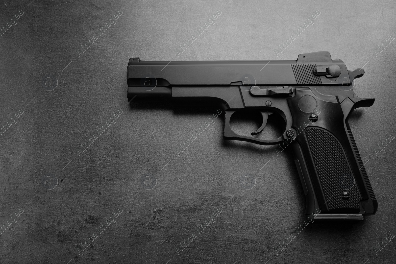 Photo of Black metal gun on stone table, top view