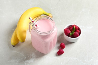 Image of Freshly made raspberry smoothie in mason jar on marble table