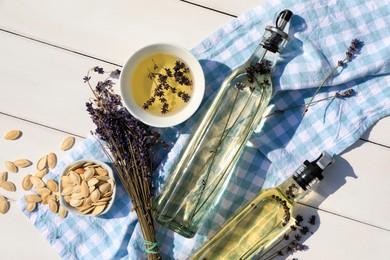 Different cooking oils and ingredients on white wooden table, flat lay