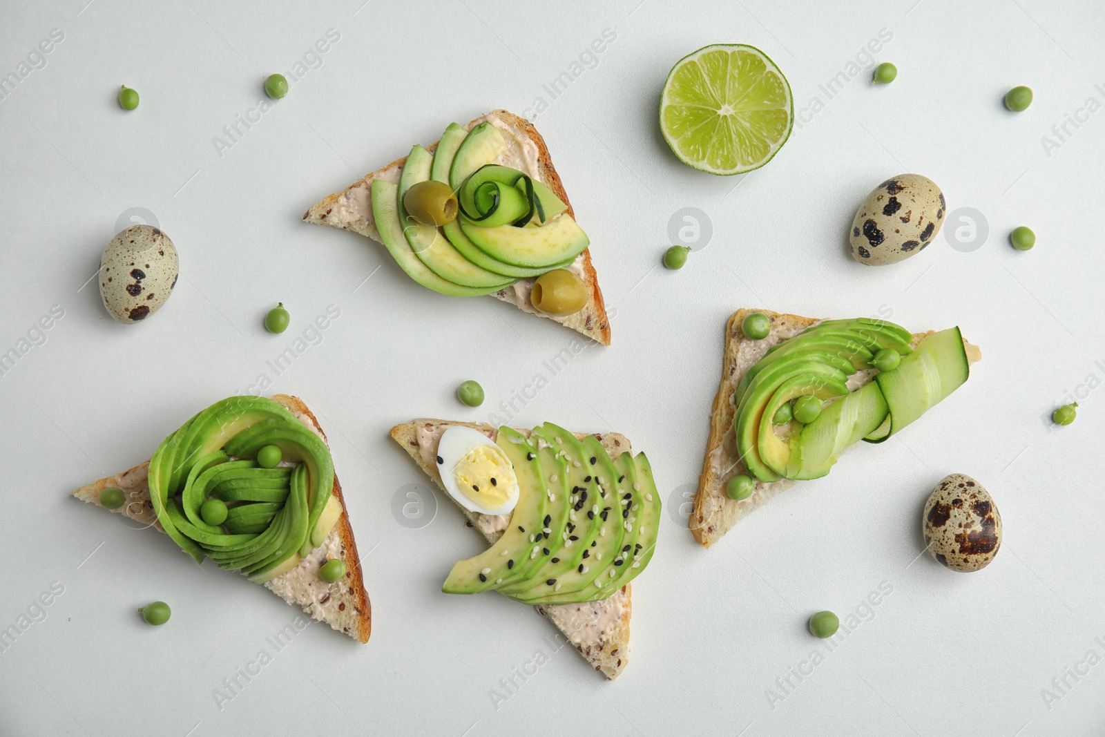 Photo of Flat lay composition with crisp avocado toasts on white background