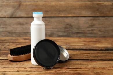 Photo of Shoe care accessories on wooden table, closeup. Space for text