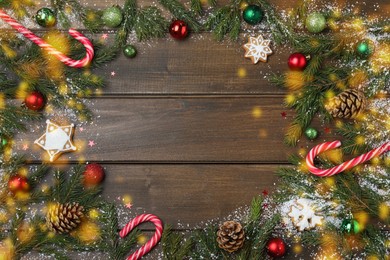 Christmas greeting card with space for text. Flat lay composition of fir tree branches and festive decor on wooden background