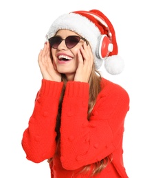 Happy young woman listening to Christmas music on white background