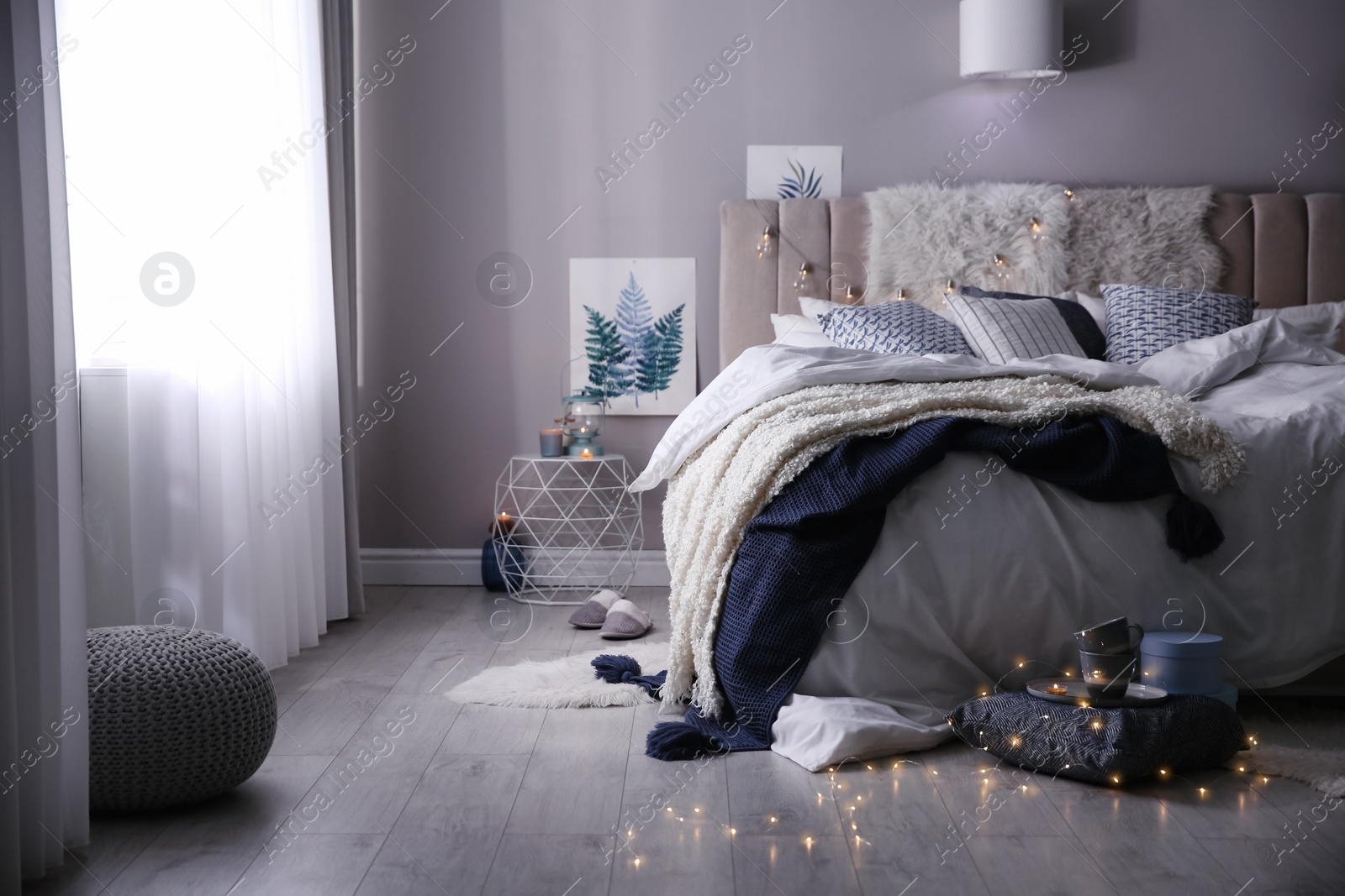 Photo of Cozy bedroom interior with warm blanket and cushions