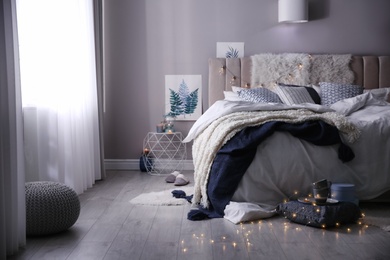 Photo of Cozy bedroom interior with warm blanket and cushions