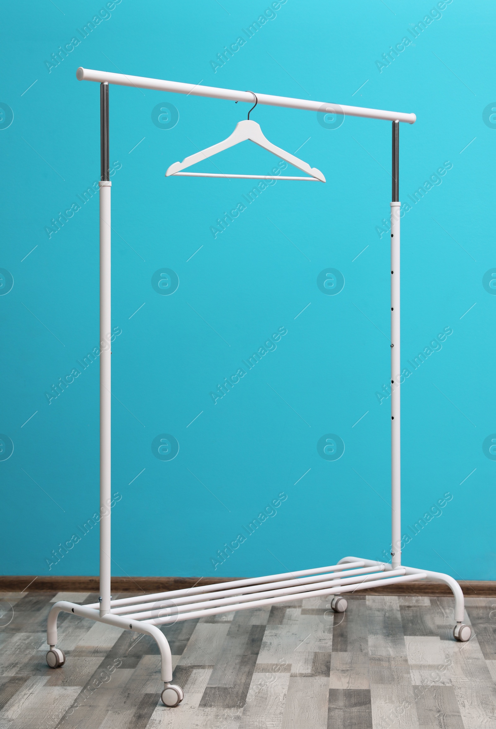 Photo of Wardrobe rack with hanger near color wall