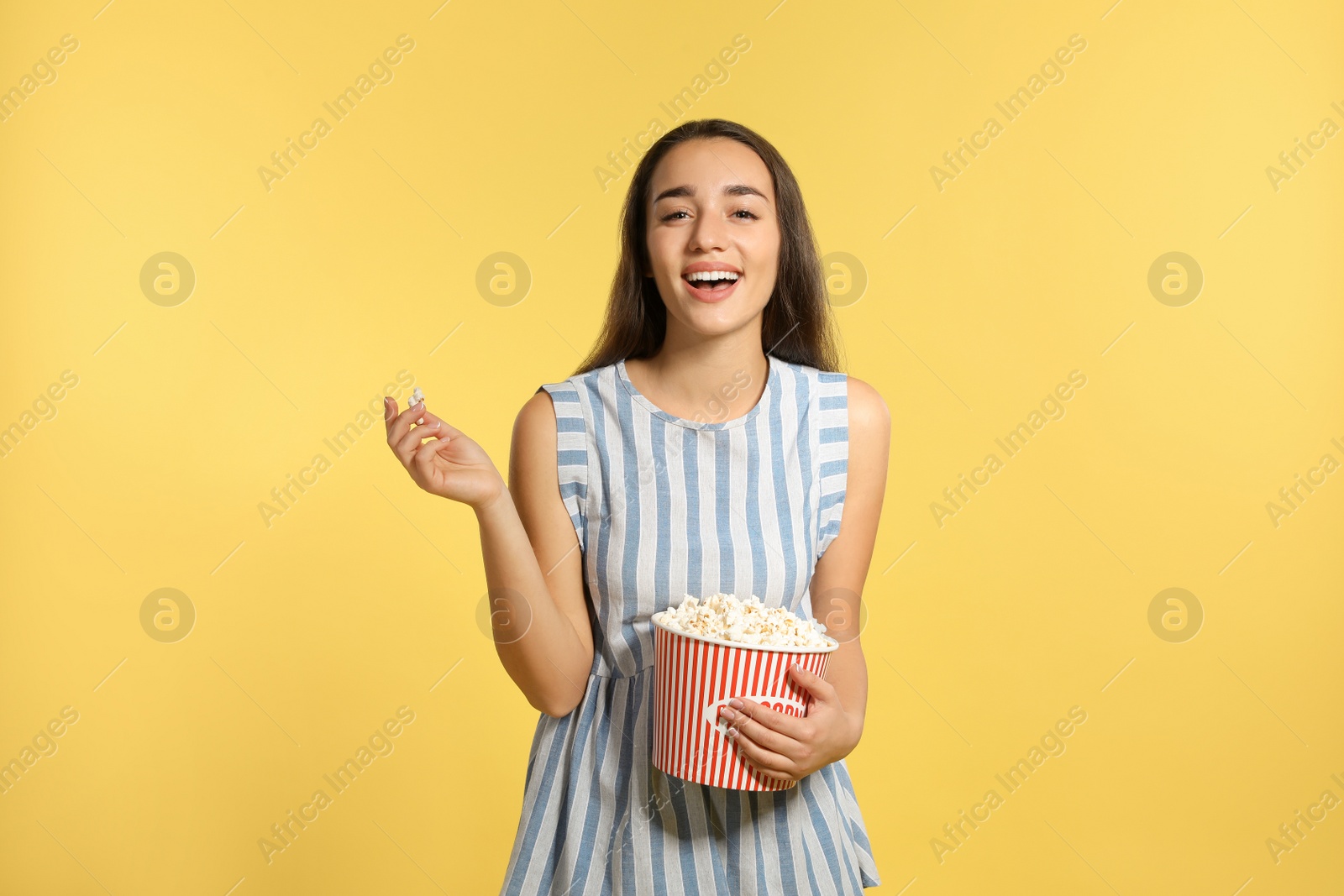 Photo of Woman with popcorn during cinema show on color background