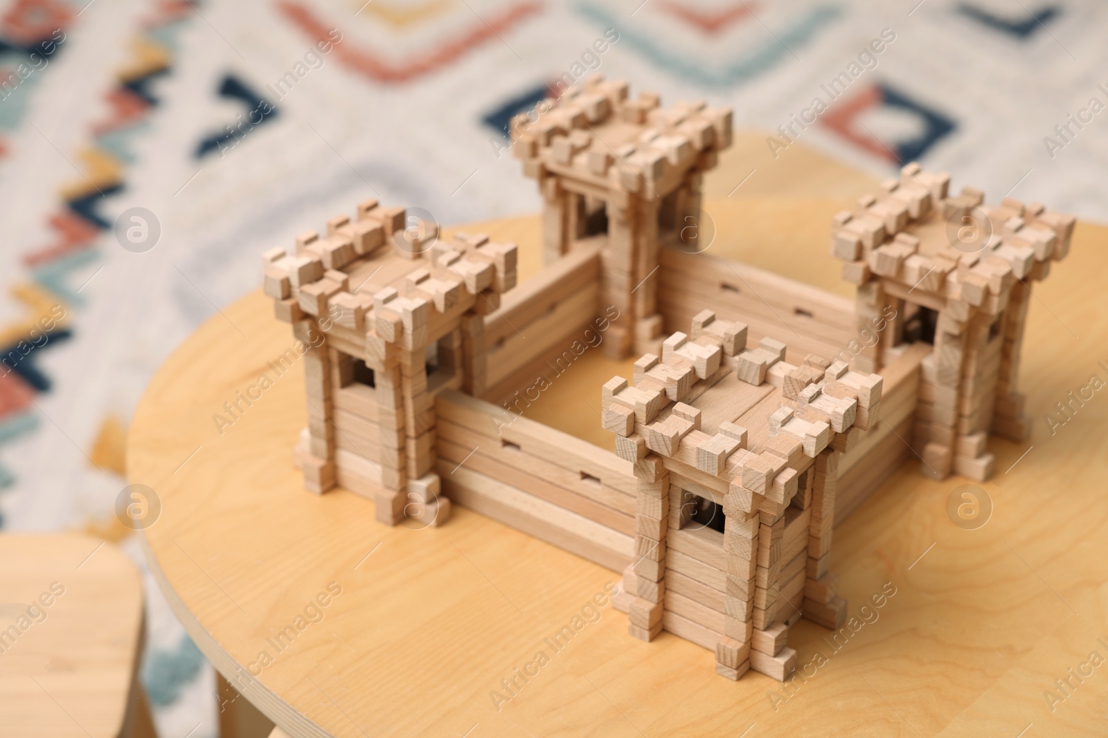 Photo of Wooden fortress on table indoors. Children's toy