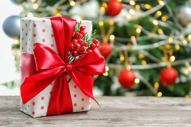 Photo of Beautiful gift box and blurred Christmas tree on background