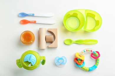 Flat lay composition with baby food and accessories on light background