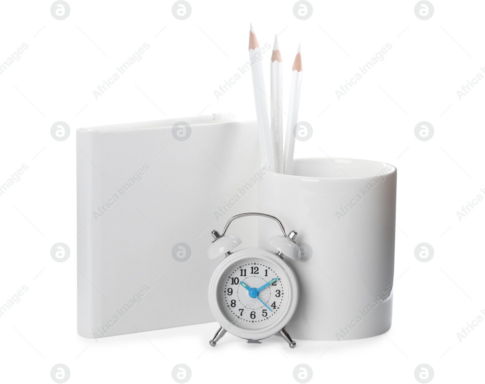 Photo of Holder with pencils, book and alarm clock on white background