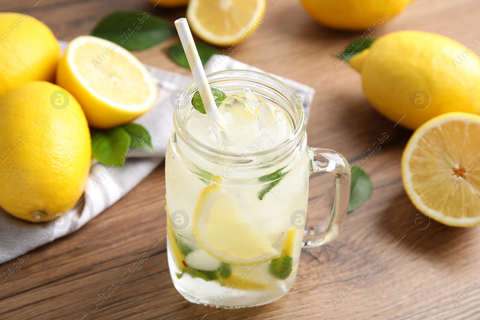 Photo of Mason jar of cold lemonade on wooden table