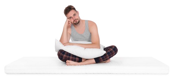 Man with pillow sitting on soft mattress against white background