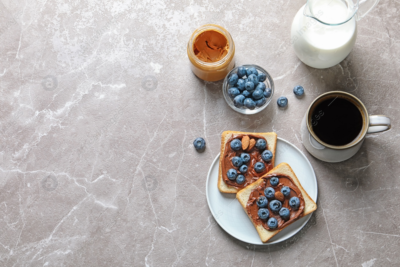 Photo of Flat lay composition with toast bread, blueberries, chocolate paste and cup of coffee on grey background