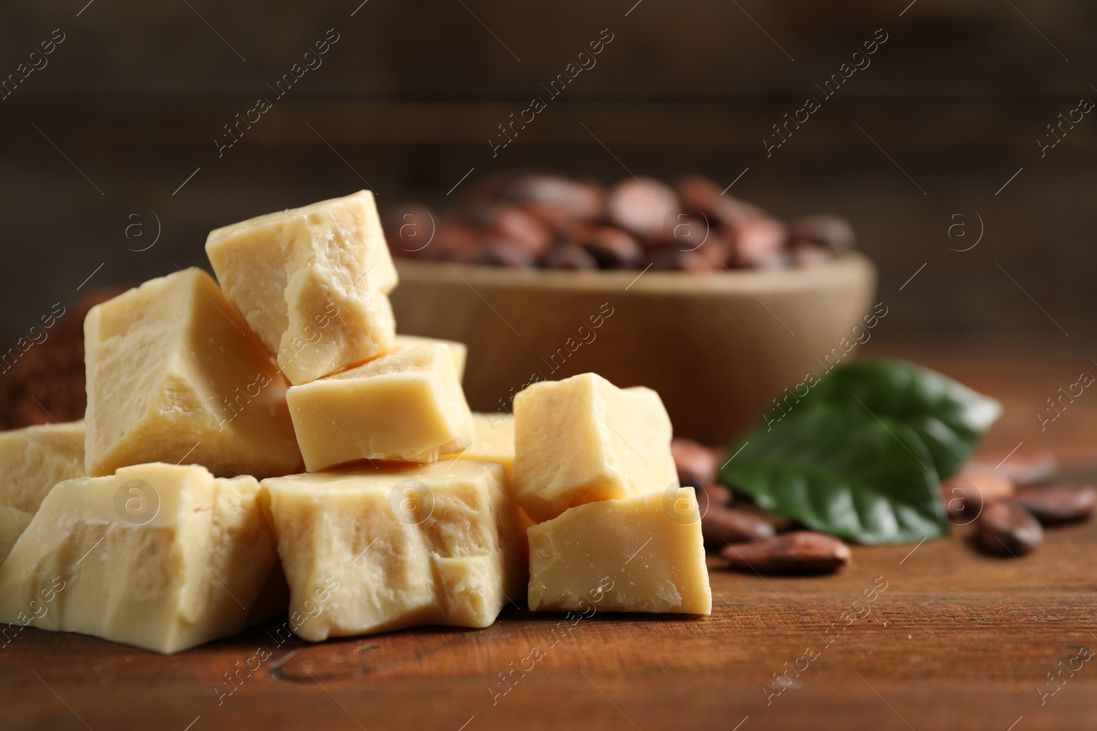 Photo of Organic cocoa butter on wooden table, closeup