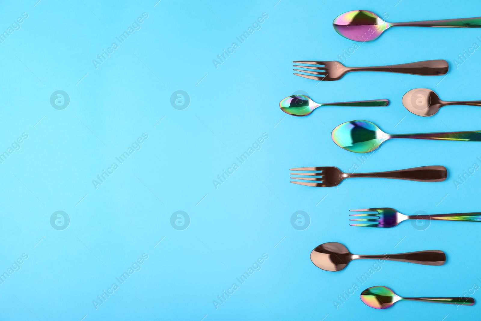 Photo of Set of new luxury cutlery on blue background, flat lay with space for text