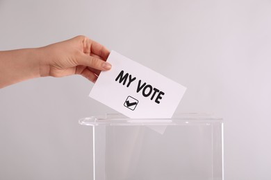 Image of Woman putting paper with text My Vote and tick into ballot box on light grey background