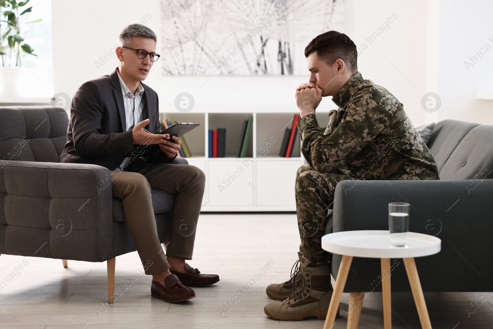 Photo of Professional psychotherapist working with military man in office