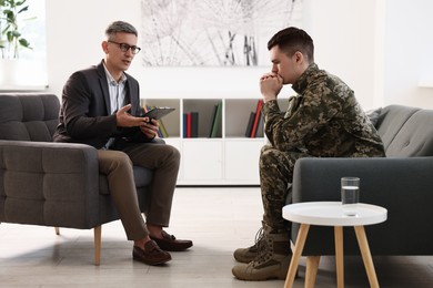 Professional psychotherapist working with military man in office