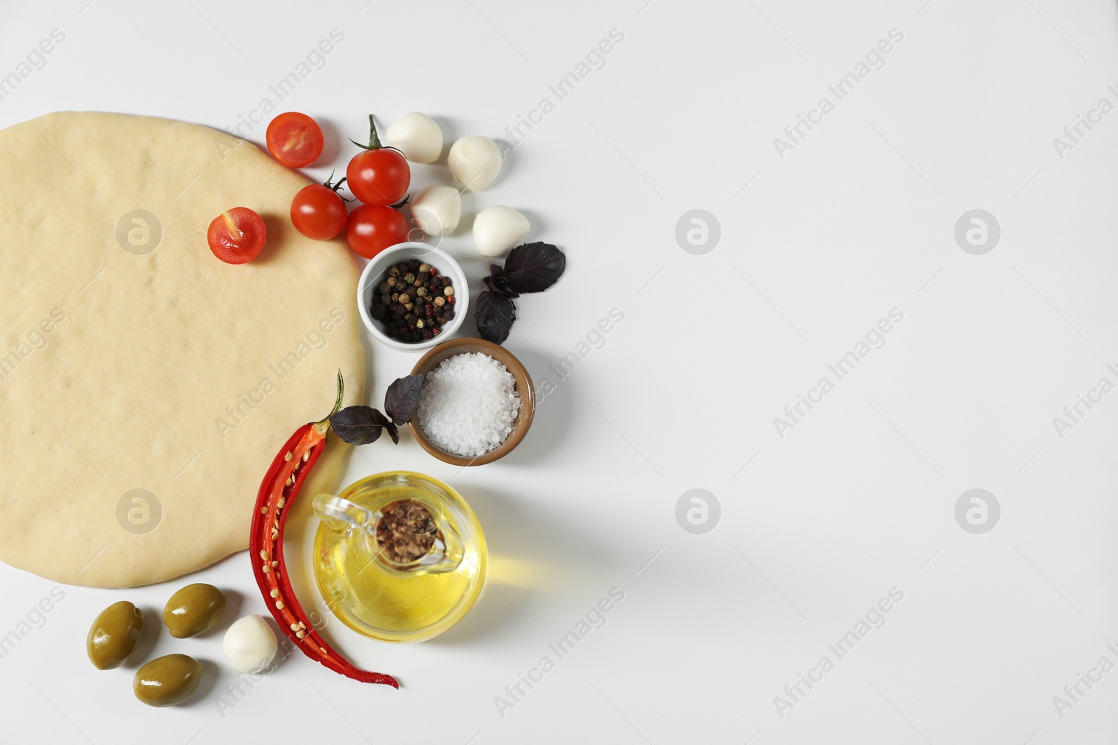 Photo of Fresh pizza dough and products on white background, flat lay. Space for text