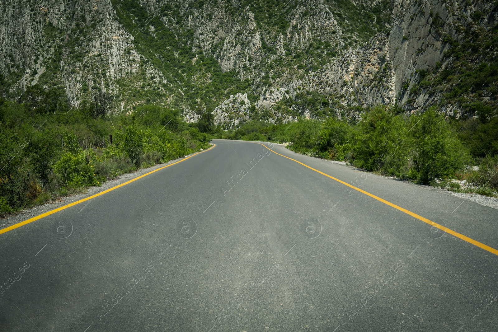 Photo of Picturesque view of big mountains and bushes near road