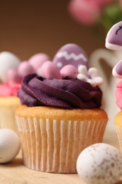 Photo of Tasty cupcake with Easter decor on table, closeup