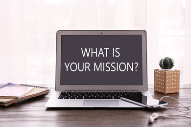 Image of Modern laptop with question WHAT IS YOUR MISSION? on screen indoors 