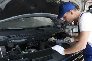 Professional auto mechanic fixing modern car in service center