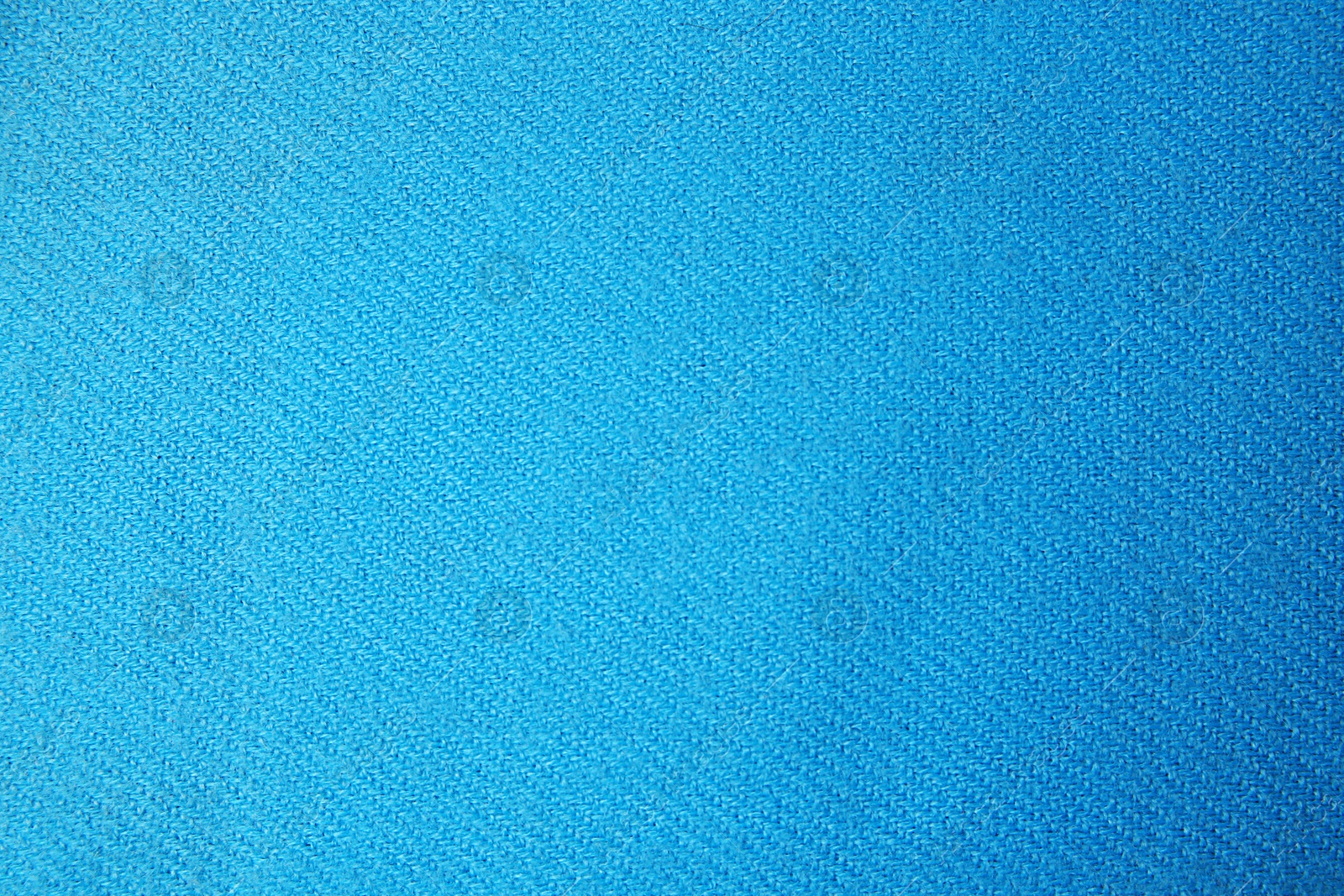 Photo of Light blue cloth with lint as background, top view. Before using fabric shaver