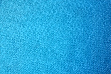 Light blue cloth with lint as background, top view. Before using fabric shaver