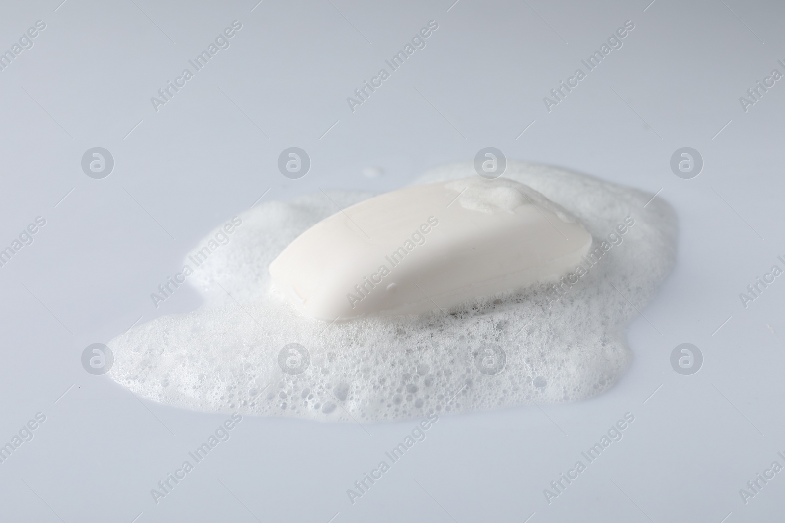 Photo of Soap with fluffy foam on white background