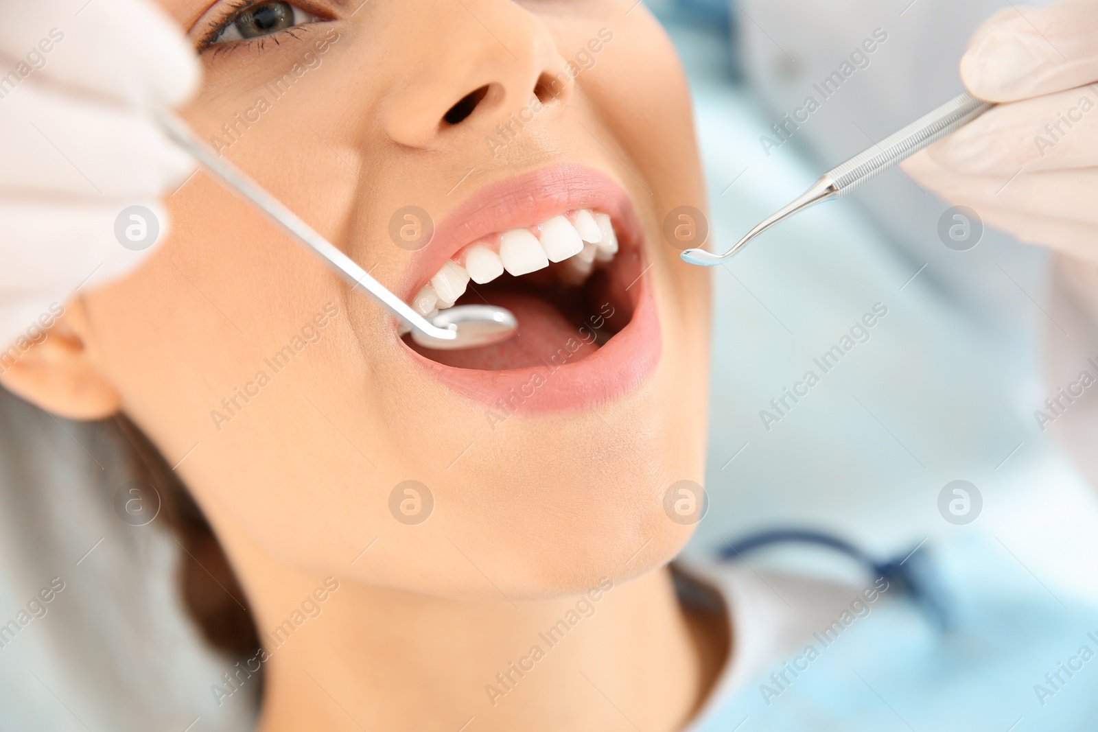 Photo of Dentist examining patient's teeth in modern clinic, closeup