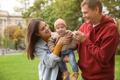 Photo of Happy parents with their adorable baby walking in park