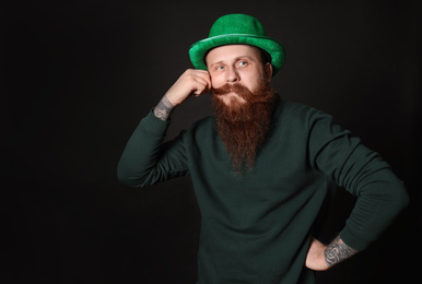 Photo of Bearded man in green hat on black background. St. Patrick's Day celebration