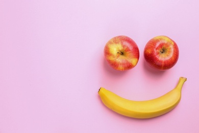 Tasty raw apples and banana on pink background, flat lay with space for text