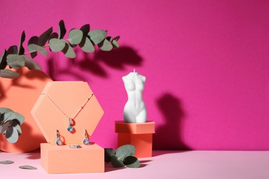 Photo of Stylish presentation of luxury jewelry on pink table. Space for text