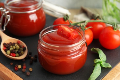 Composition with tomato sauce in jars on table