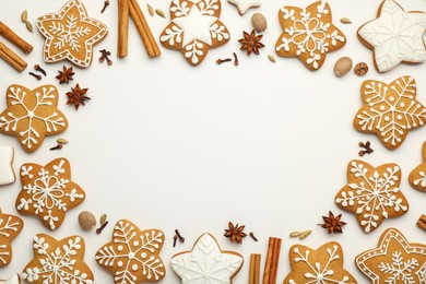 Photo of Frame made of tasty Christmas cookies with icing and spices on white background, flat lay