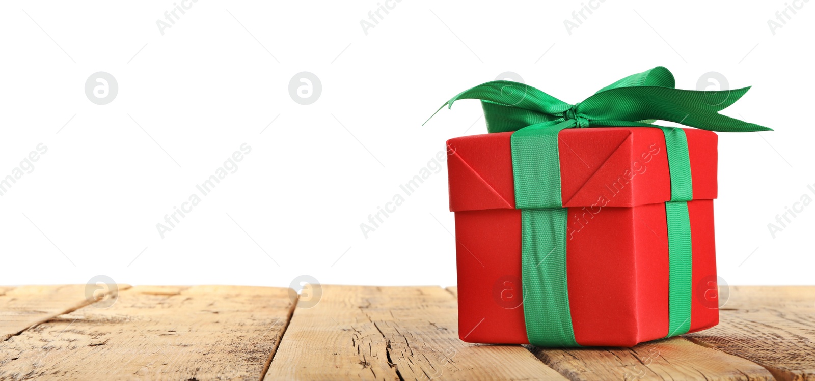 Photo of Christmas gift on wooden table against white background. Space for text