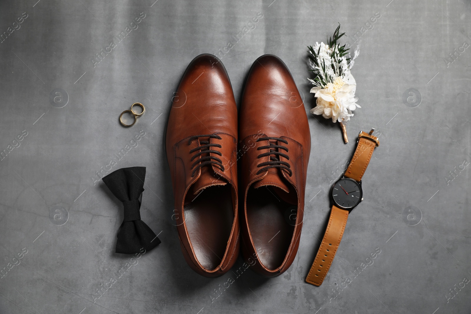 Photo of Wedding stuff. Flat lay composition with stylish boutonniere on gray background