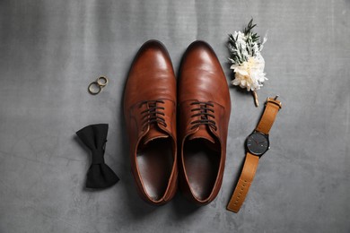 Photo of Wedding stuff. Flat lay composition with stylish boutonniere on gray background