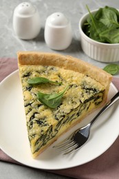 Photo of Piece of delicious spinach pie served on light table
