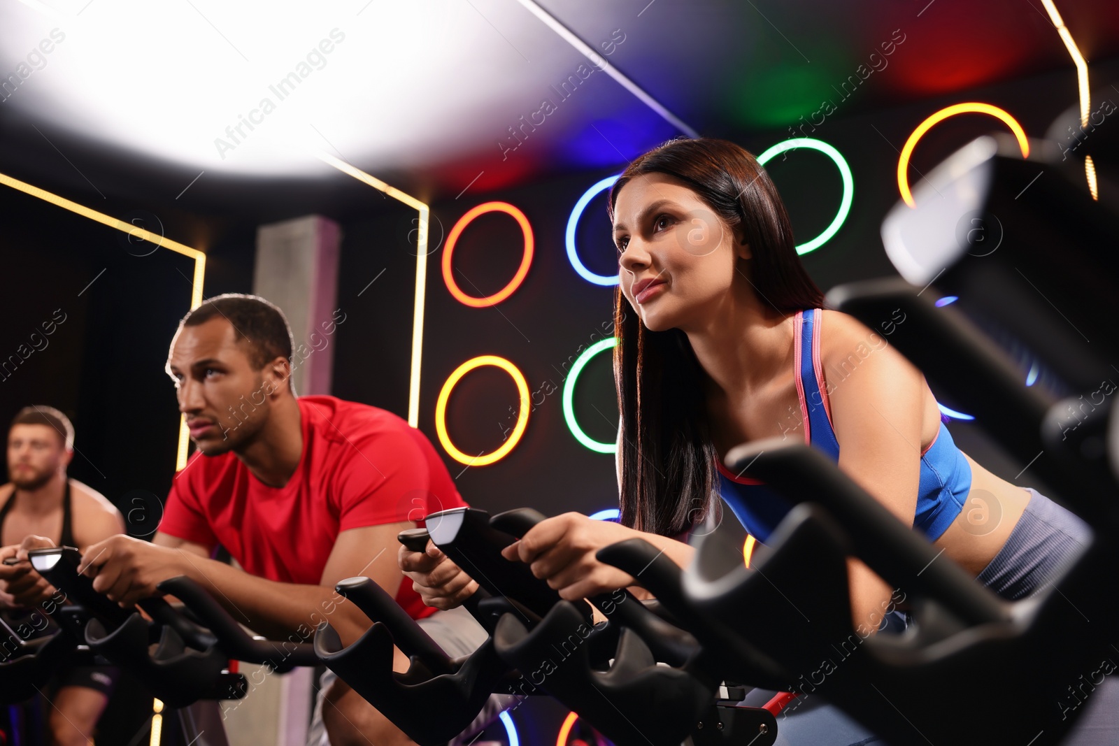 Photo of Group of people training on exercise bikes in fitness club