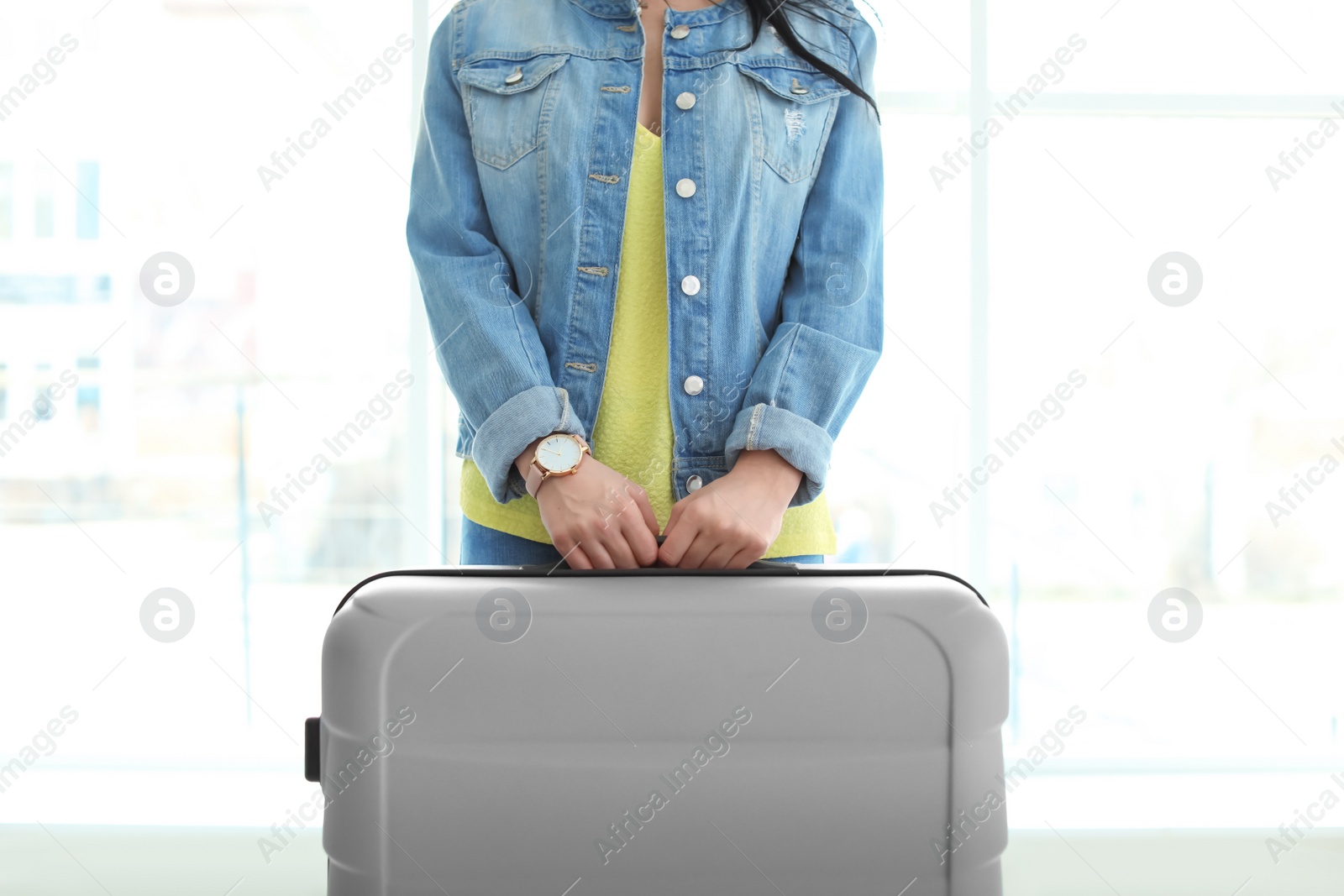 Photo of Young woman with suitcase indoors