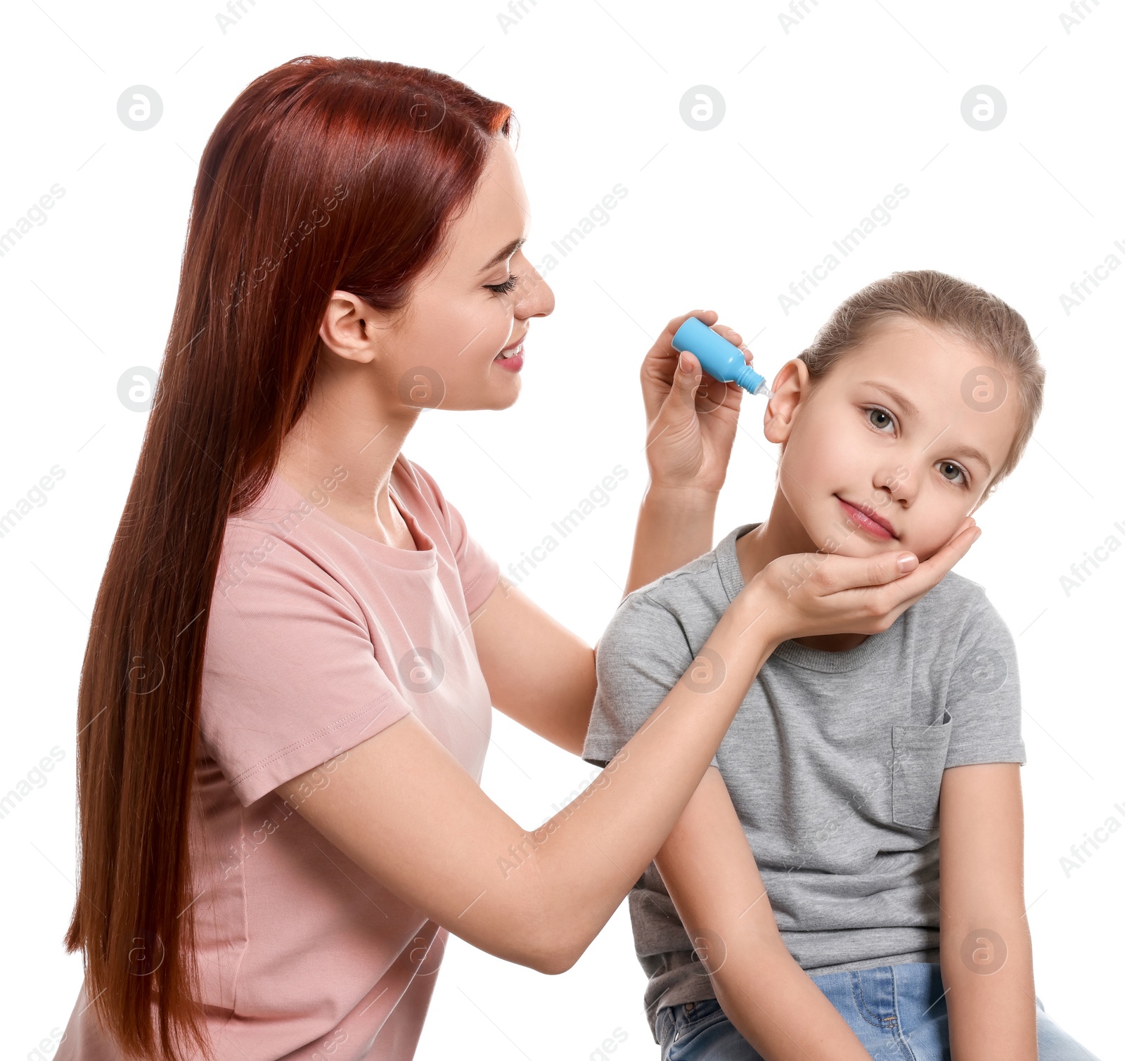 Photo of Mother dripping medication into daughter's ear on white background