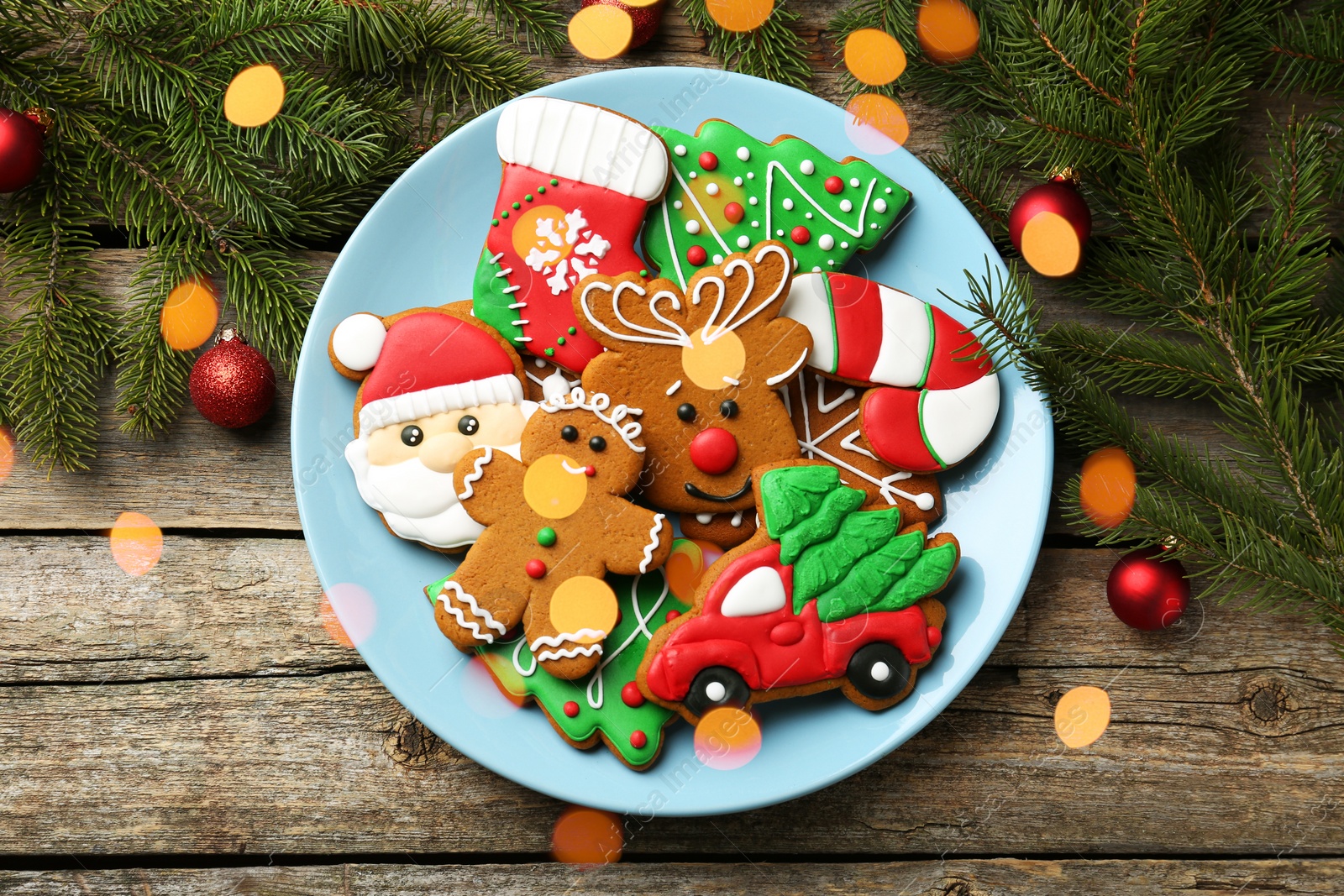 Photo of Different tasty Christmas cookies and decor on wooden table, flat lay