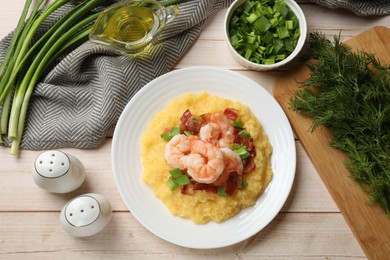 Photo of Plate with fresh tasty shrimps, bacon, grits and green onion on light wooden table, flat lay