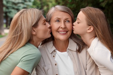 Photo of Three generations. Happy grandmother, her daughter and granddaughter outdoors