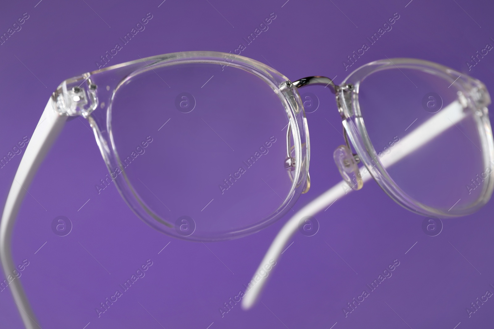 Photo of Stylish pair of glasses on purple background, closeup