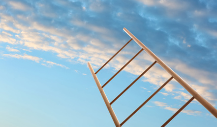 Image of Wooden ladder against blue sky with clouds, low angle view. Banner design 